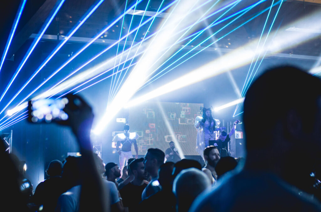 Lasers, stage performers and dancing people fill the room at the festival's Snowball event.