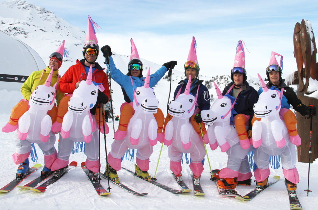 A Whistler Pride festival ski group dressed in unicorn outfits gather at the top of Whistler Blackcomb.