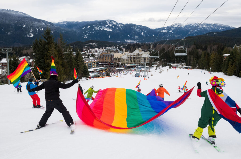 Skiers carrying a huge rainbow flag make their way down Whistler Blackcomb in the Pride Parade.