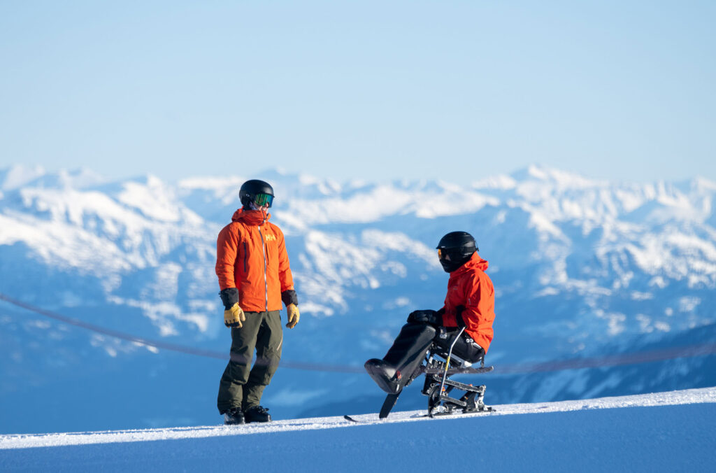 A Whistler Adaptive coach talks to a sit skier on Whistler Blackcomb.