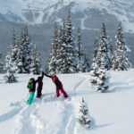 A group of teenagers high five on Whistler Blackcomb as they enjoy a day skiing.