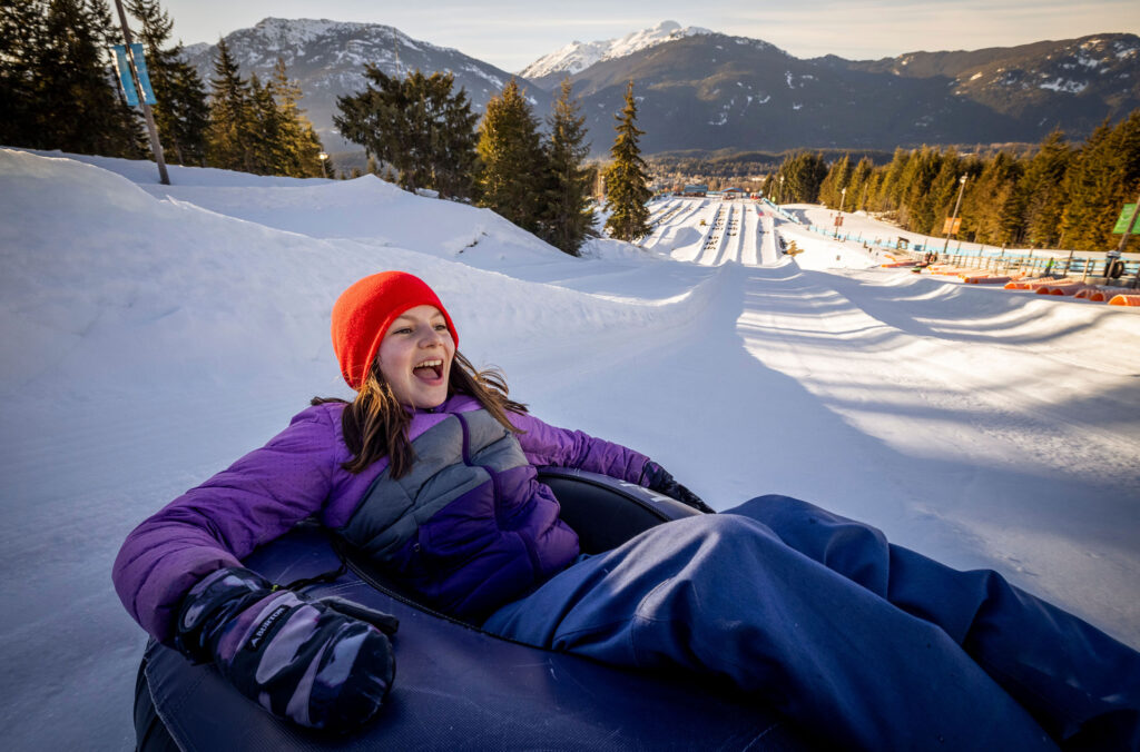 A teenage girl tubes down an icy lane at the bubly Tube Park in Whistler.