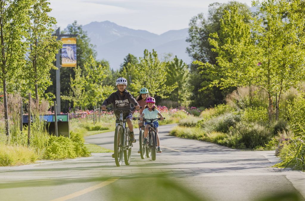 A family of three ride bikes along the Valley Trail in Whistler.