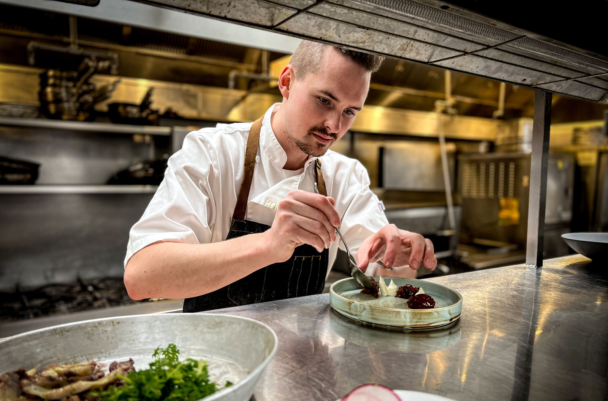 Chef Sean Thornhill adds the finishing touches to a dish in the kitchen of the Fairmont Chateau Whistler.