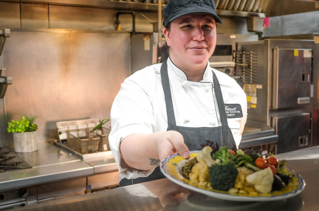 Robyn Gallagher is the first cook and chair of the sustainability team for the Fairmont Chateau Whistler. In this shot, she's serving a plate of salad at the staff cafeteria.