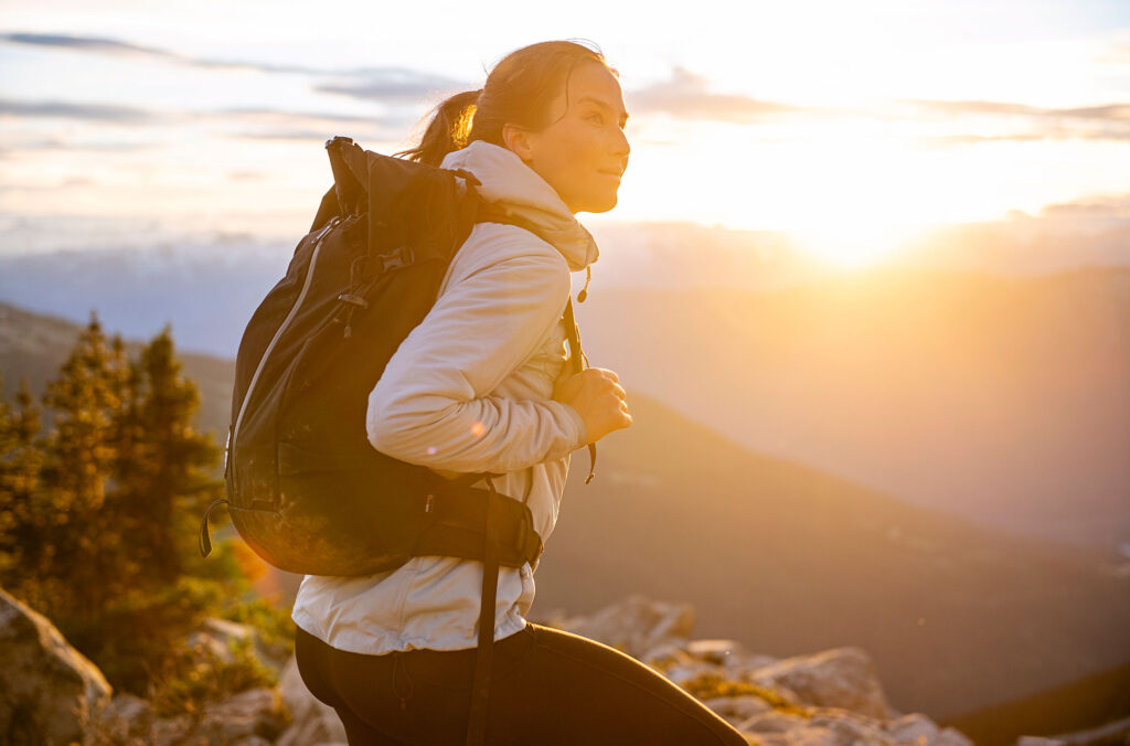 A woman enjoys the sunset at the top of Whistler Mountain in the high alpine.