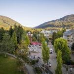 Whistler Village in the spring with a view of part of the Village Stroll and Whistler and Blackcomb Mountains in the background.