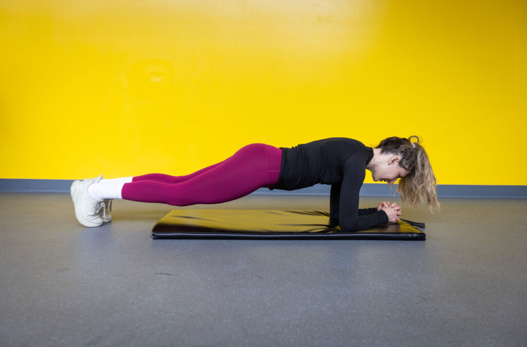 Pro biker, Hailey Elise, performs a plank, a great exercise for getting ready to bike season.