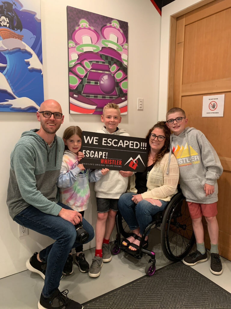 Codie Darnell and her family hold the successful we escaped sign after completing Escape! Whistler.