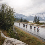 Cyclists make their way up the Sea to Sky in the GranFondo with the ocean on their left and the mountains ahead of them.