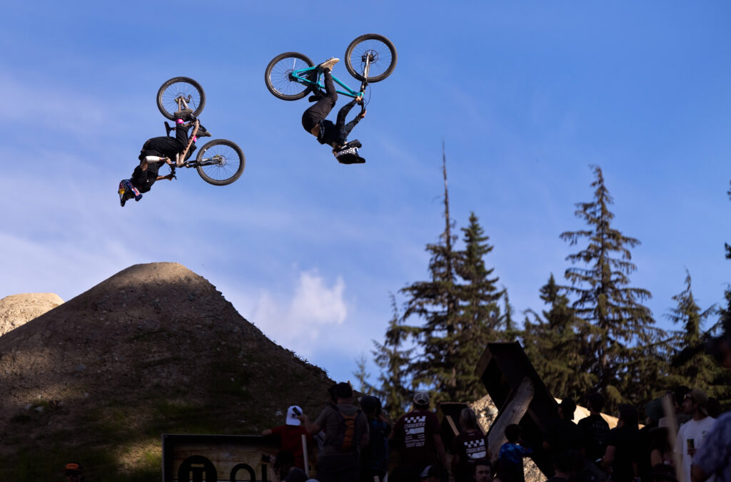 Two bikers spin skillfully in the air during Speed and Style at Crankworx Whistler.