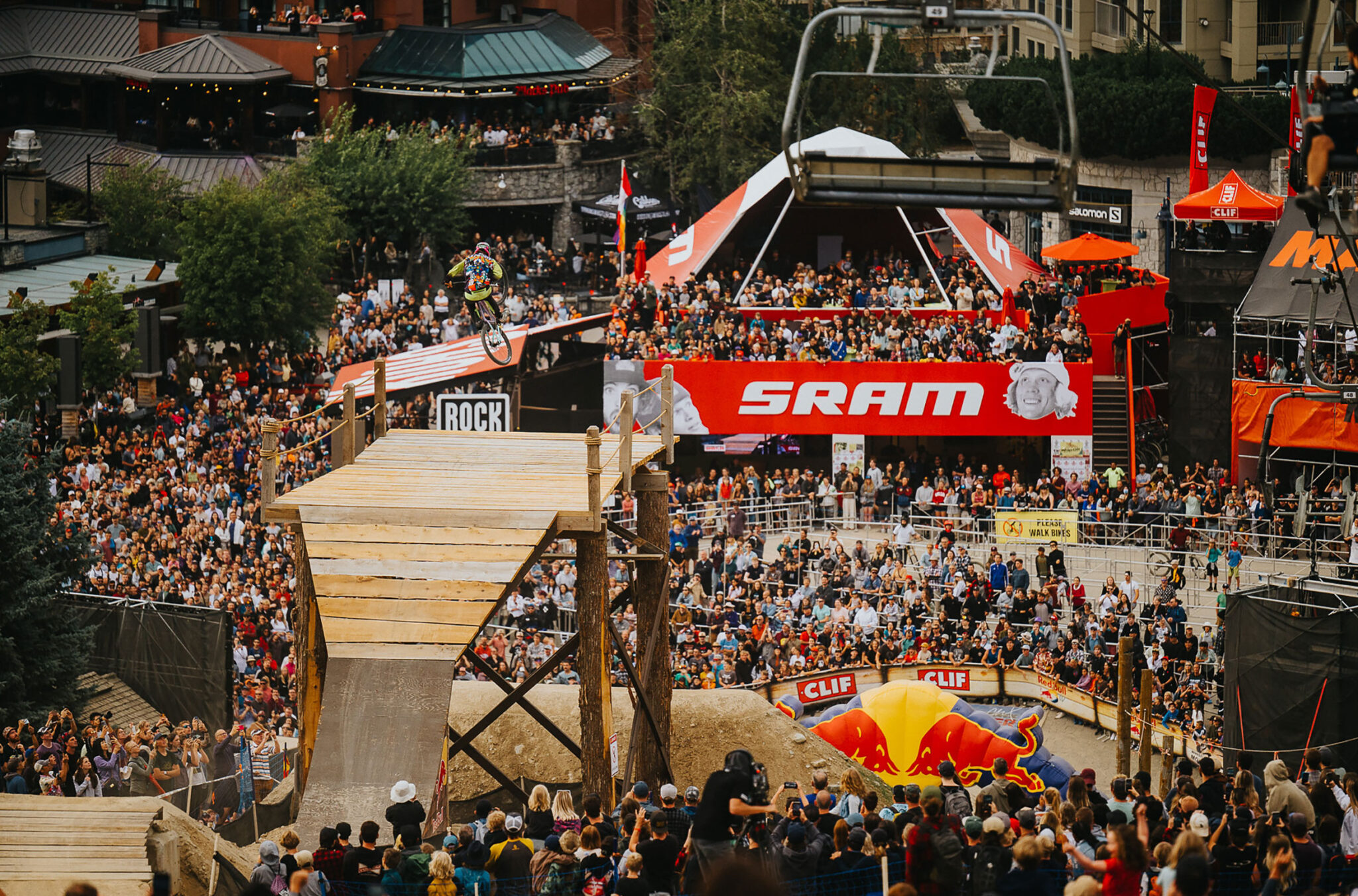 A shot from the hill looking out over the Redbull Joyride crowd as a bike athlete launches off a wooden bridge.