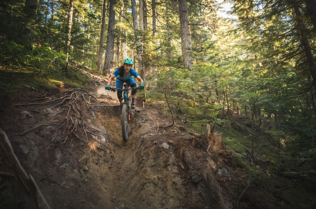 A mountain biker comes down a rock roll on the Micro Climate trail in Whistler.