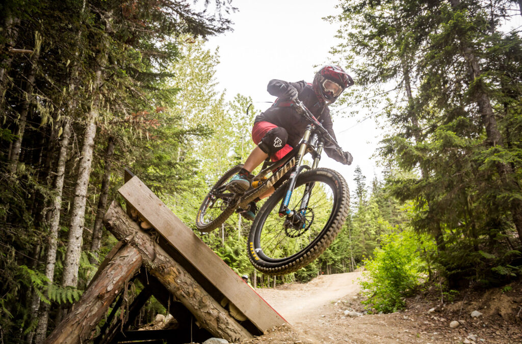 A mountain biker tackles some woodwork in the Whistler Mountain Bike Park.