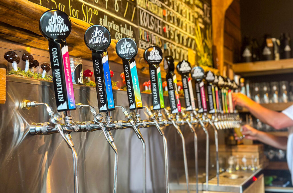 A shot of the colourful beer taps lined up behind the bartenders at Coast Mountain Brewing.