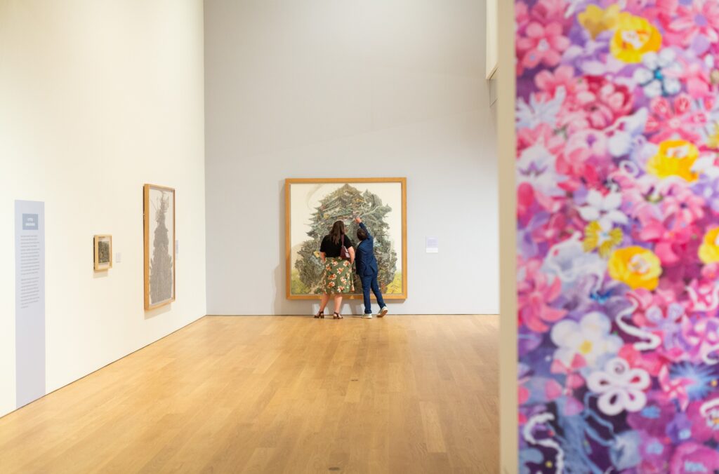 Two women admire one of the artworks at the Flowers from the Wreckage exhibit at the Audain Art Gallery in Whistler.