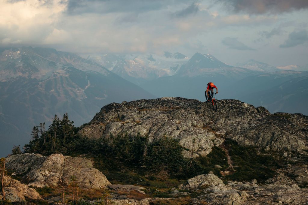 A biker rides along the top of a mountain in Whistler's alpine.
