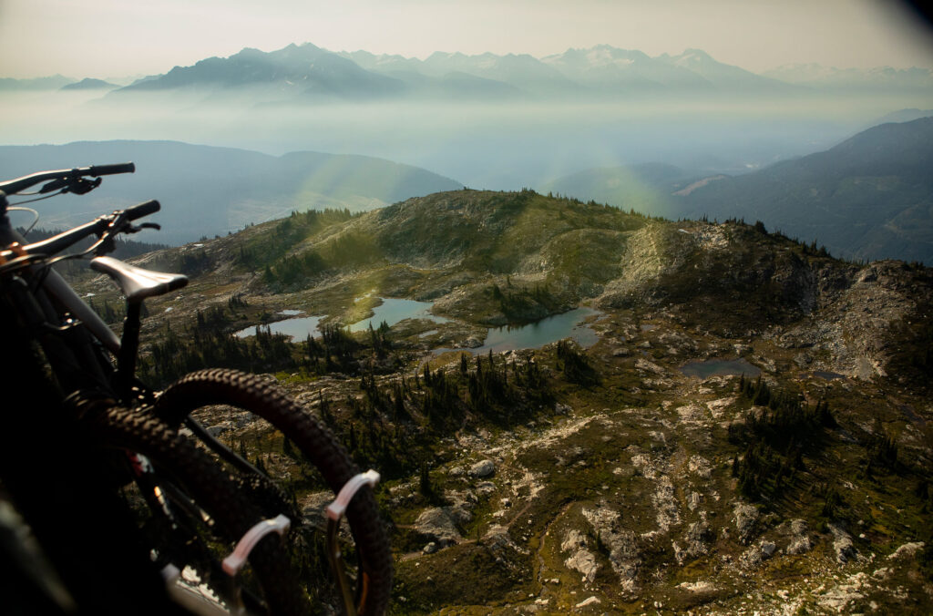 The view out of the helicopter with the Coast Mountains in the background and the bikes in the foreground, strapped onto the side of the helicopter.