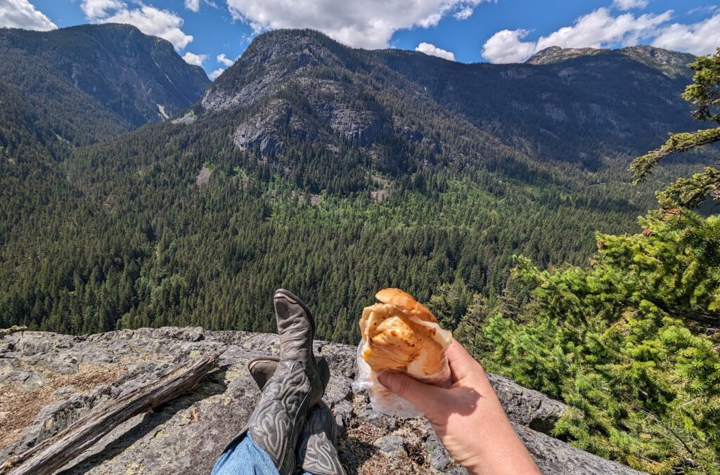 A sandwich and cowboy boots with mountain backdrop