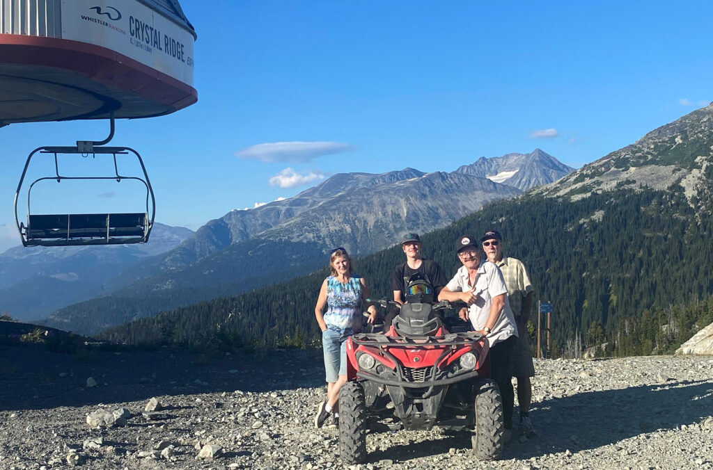 Feet and his family pose around an ATV at the top of the Crystal Ridge chairlift on Blackcomb Mountain.