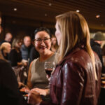 A group of friends drink wine at the Audain Art Museum while on the Whistler Wine Walk.