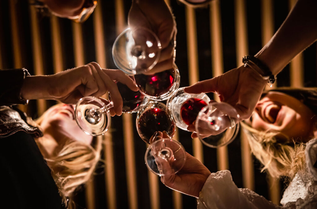 A group of friends cheers with their wine glasses at the Audain Art Museum while on the Whistler Wine Walk. 