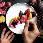 A chef adds the finishing touches to a beautiful plate of fall-coloured food during Whistler Cornucopia.