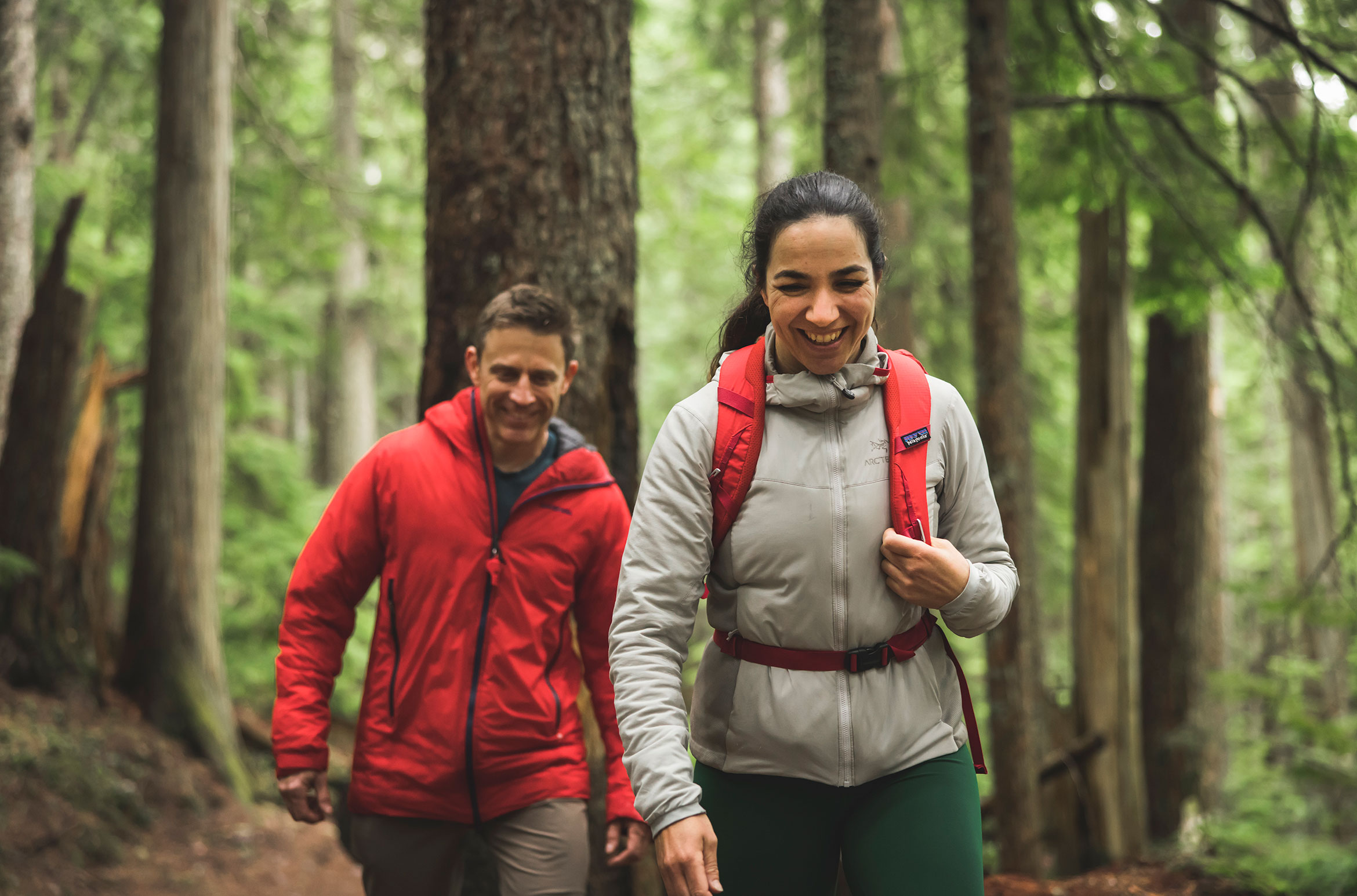 A couple hike in Whistler's lush temperate rainforest in the fall.