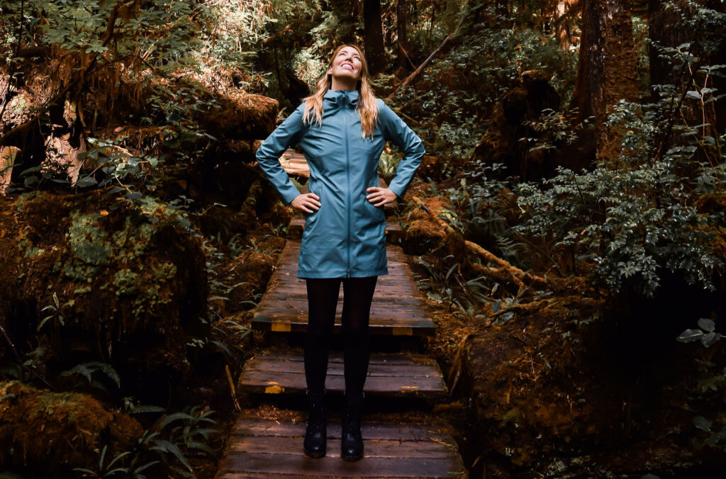Emily Kane stands on a wooden step in Whistler's lush temperate rainforest.