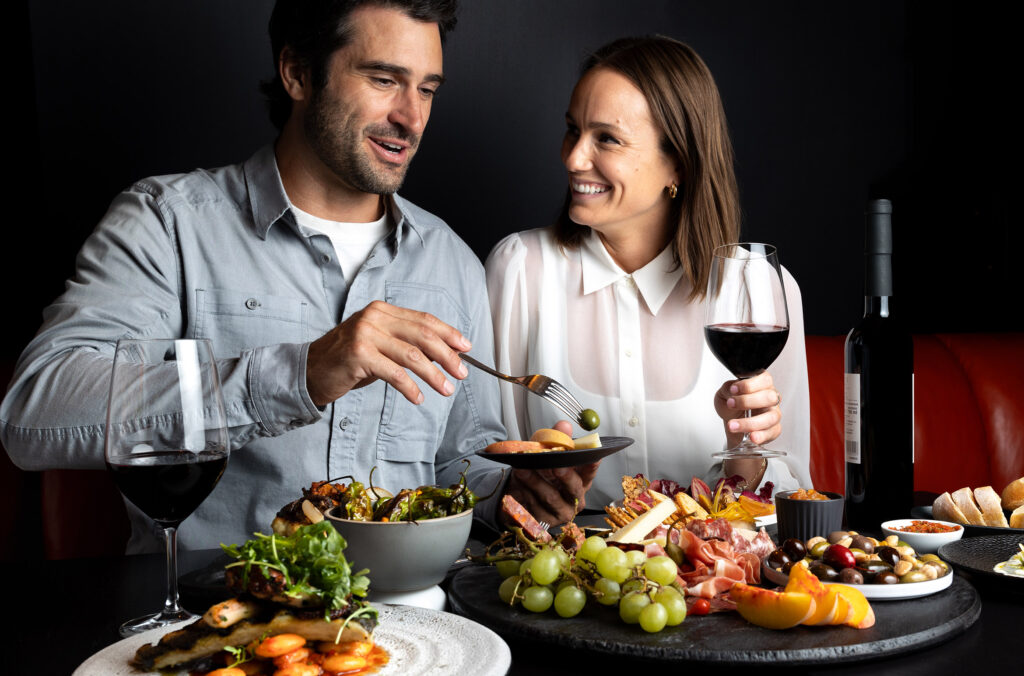 A couple enjoy a colourful array of foods while drinking wine at Whistler Cornucopia.