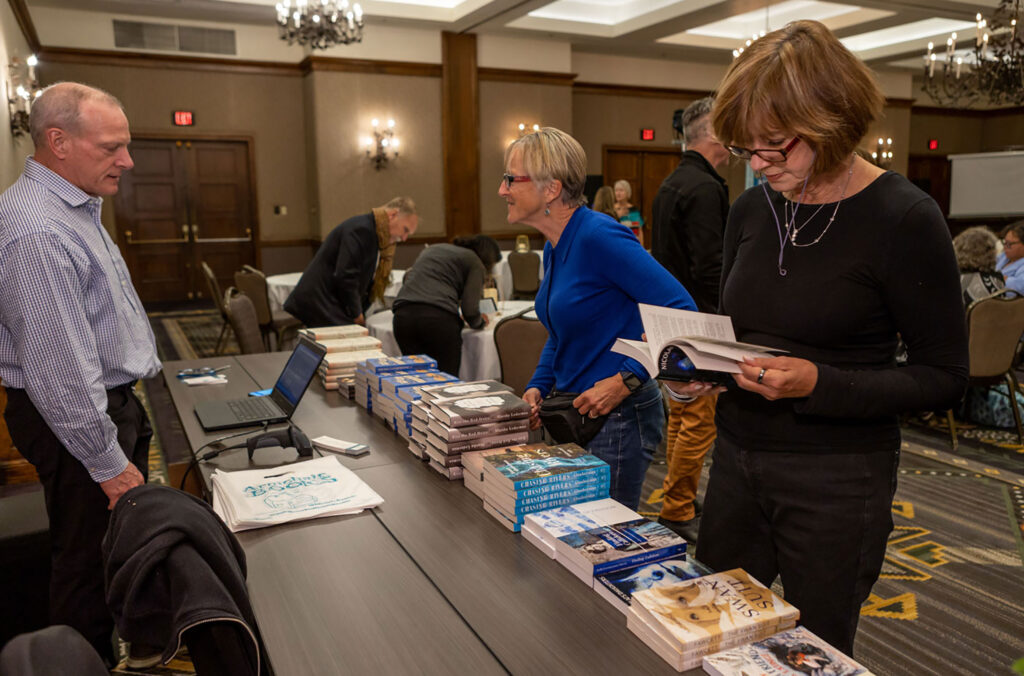 Two event goers look at the books by the authors at one of the Whistler Writers Festival events.