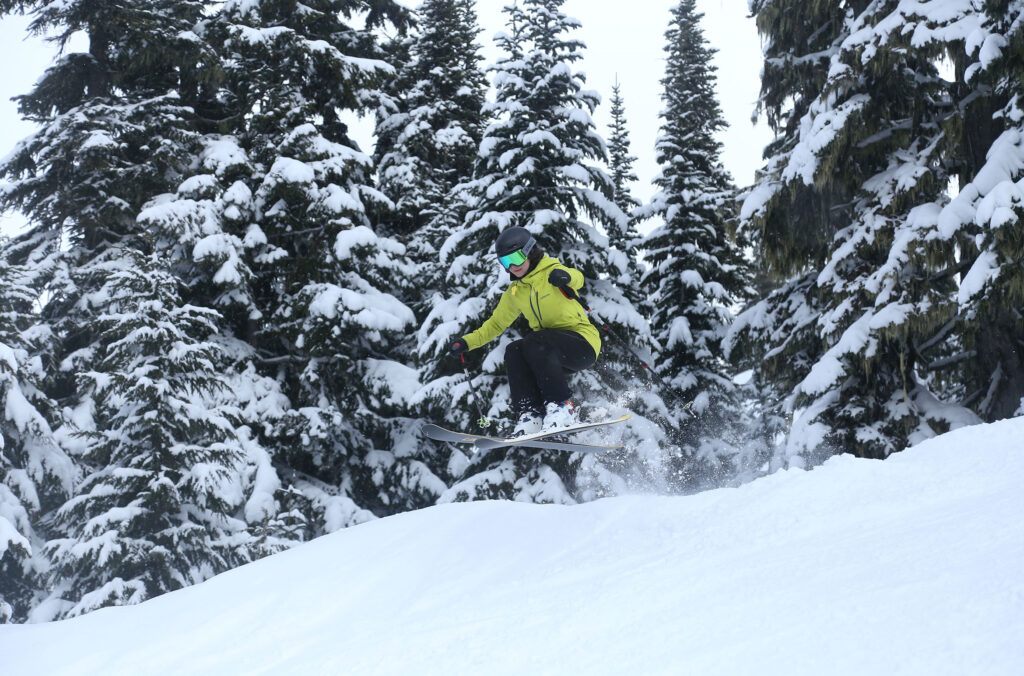 A skier does a small jump on the slopes on Whistler Blackcomb.