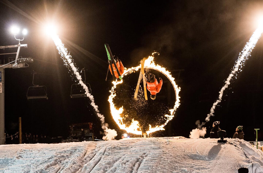 Ski and snowboard athletes fly through rings of fire in the Fire & Ice Show in Whistler.