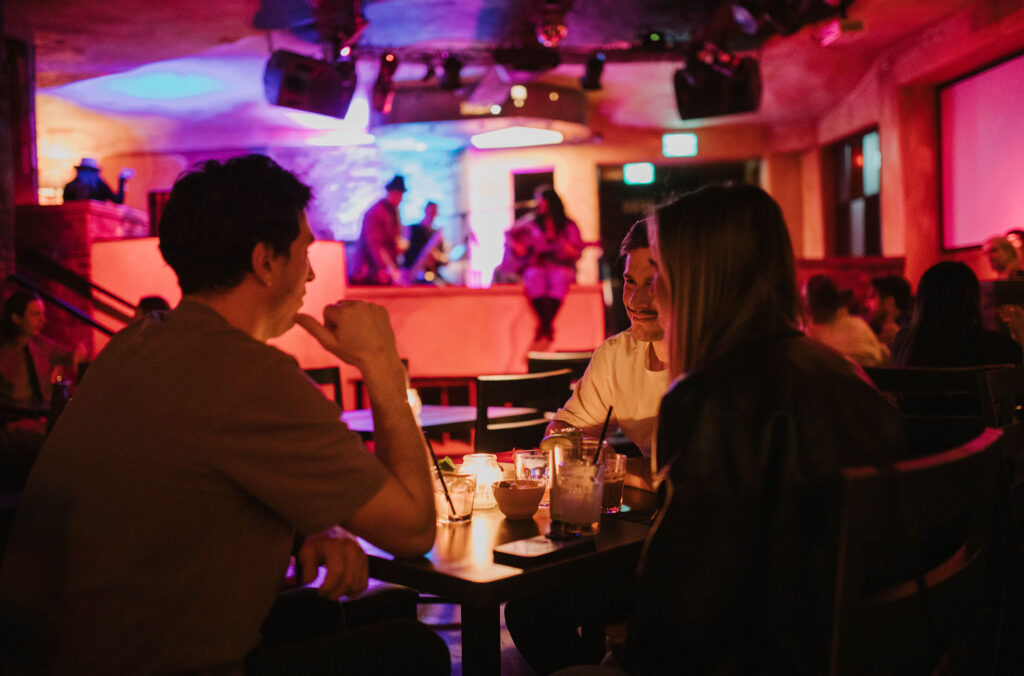 People sit at a table with drinks enjoying live music at Maxx Fish in Whistler.