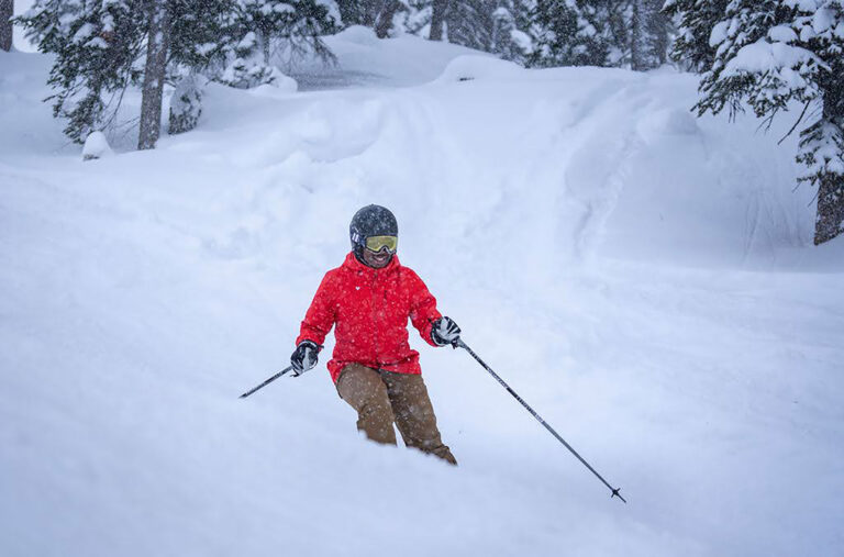 Ojo skiing down the slopes as it snows.