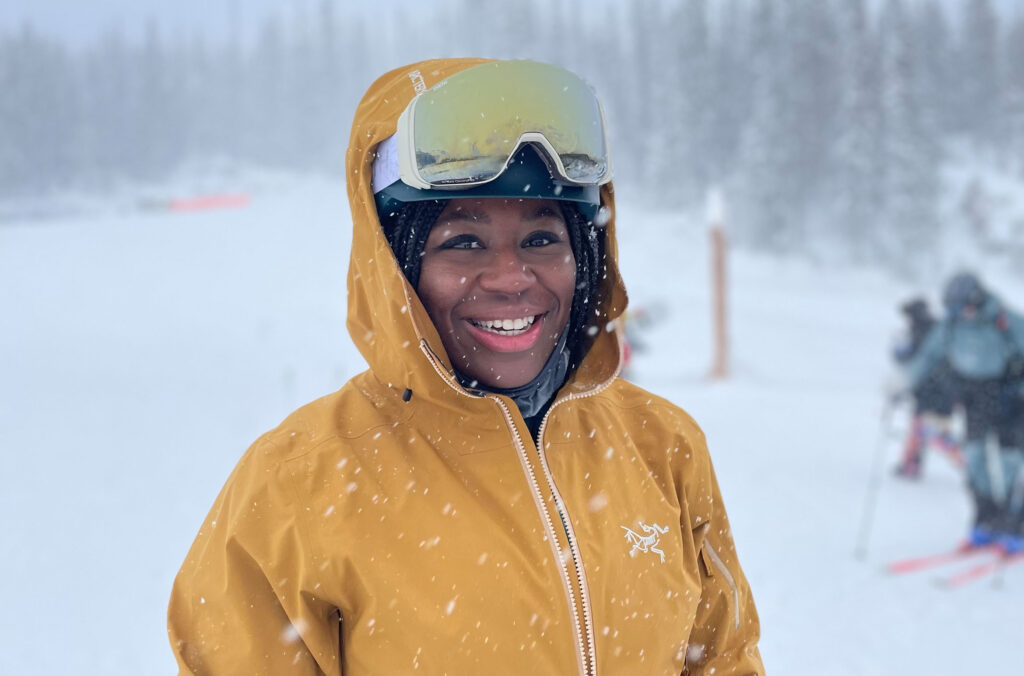 Ojo looks directly to the camera in her ski gear while on a ski lesson with Colour the Trails. 