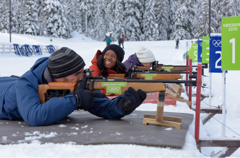 Three people try their hand at rifle shooting at the Biathlon range at Whistler Olympic Park.