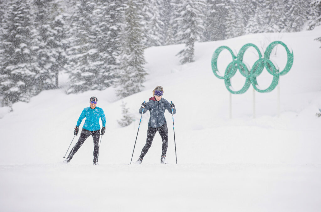 Two cross-country skiers power up the slopes in the snow at Whistler Olympic Park.