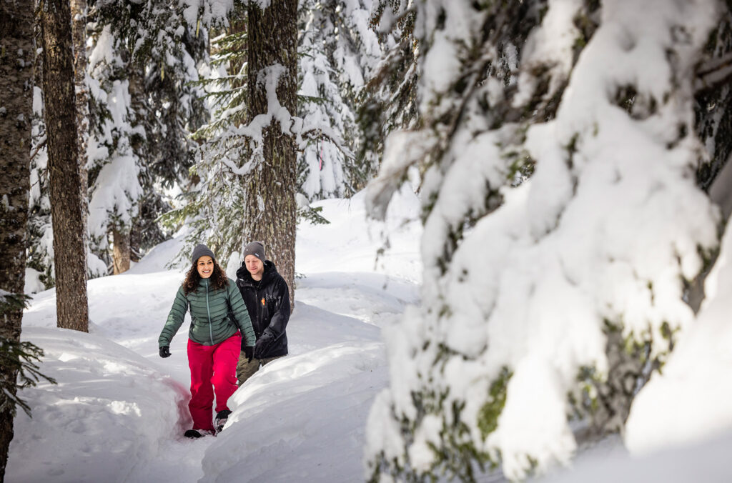 Two snowshoers explore the trails in the forest at Whistler Olympic Park.