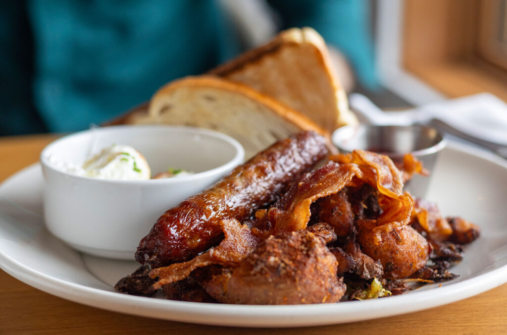 A plate piled high with breakfast favourites - eggs, sausages and bacon.