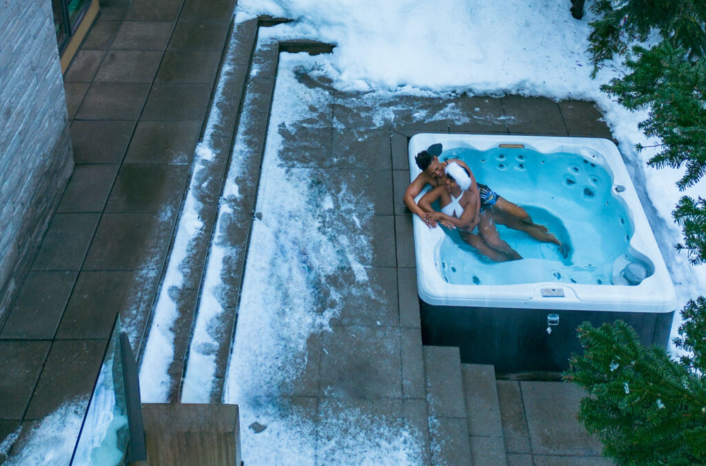 A couple relax in a hot tub at one of Whistler's luxury accommodation options in the winter.