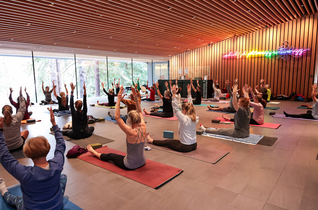 People reach for the ceiling at a yoga class happening in the lobby area of the Audain Art Museum in Whistler.