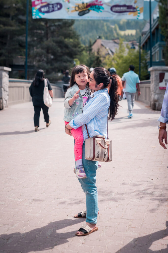 A mother and daughter hug on the Whistler Village Stroll during the Whistler Children's Festival.