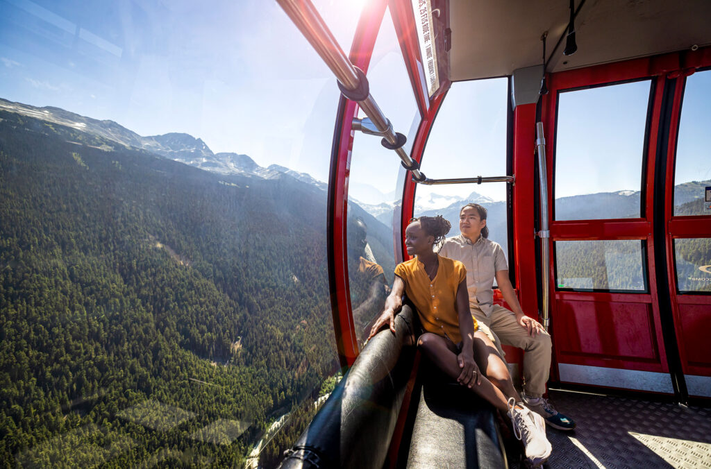 A couple sit on the PEAK 2 PEAK and gaze out over the 360 degree views in the summer.