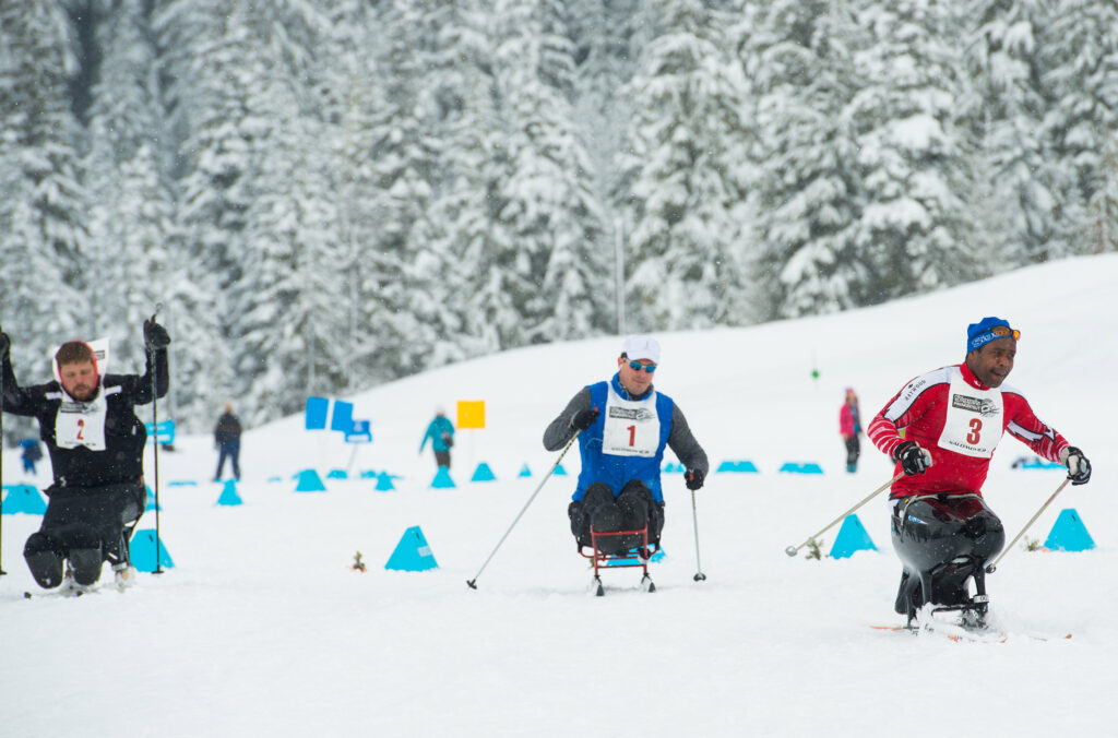 Three sit-ski athletes take part in cross-country ski race at Whistler Olympic Park.