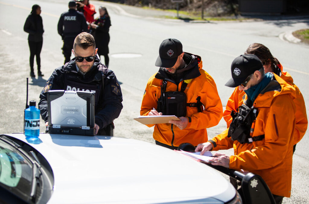 Police and FireSmart officers gather around as they organize the emergency evacuation drill training in Whistler.