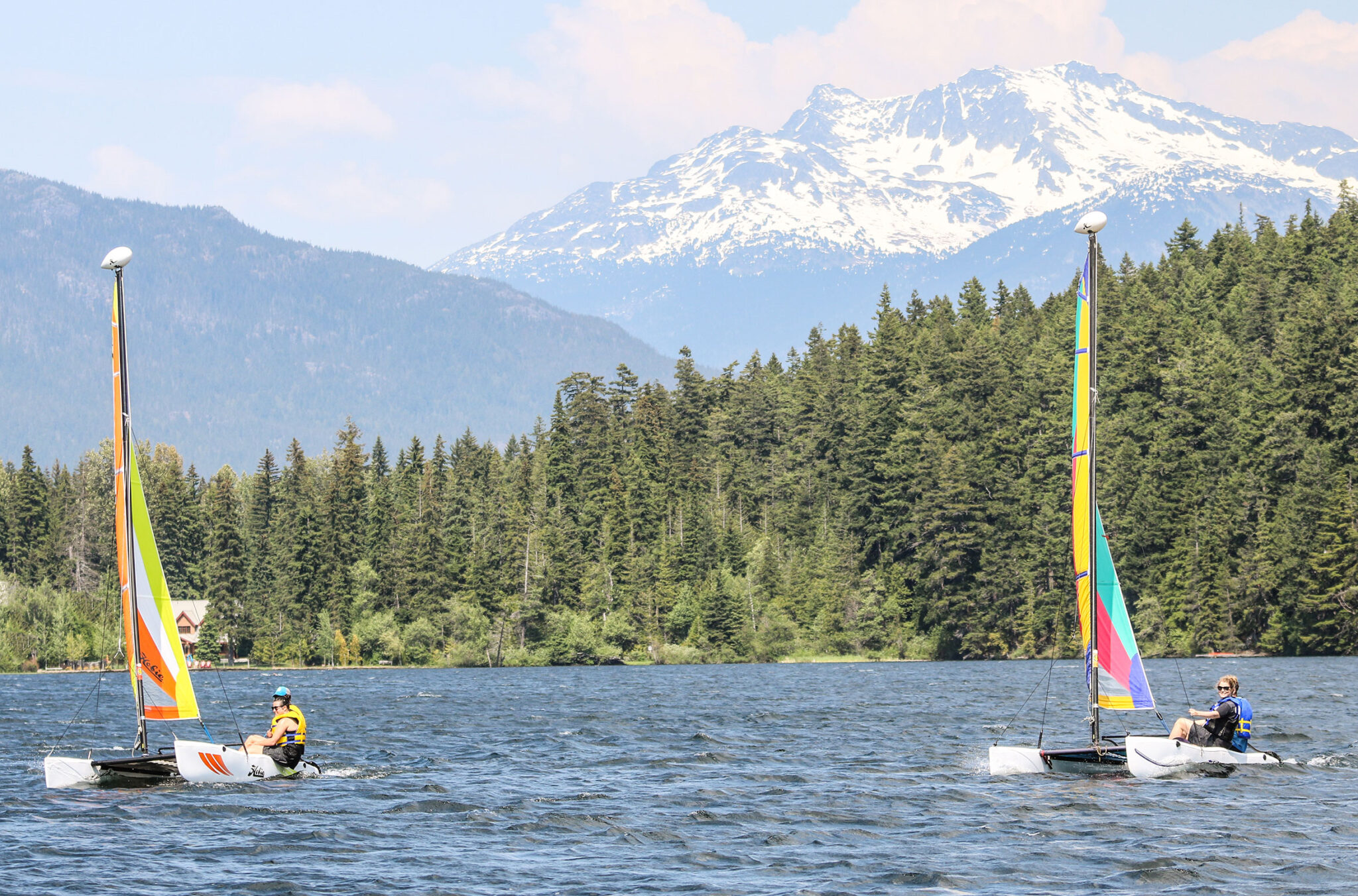Two sail boats race across the waters of Alta Lake in Whistler.