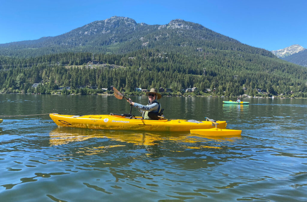 Sean Marihugh in an adaptive kayak on Alta Lake – the kayak has an articulating mount for the paddle which supports the weight of the paddle, and two pontoons add stability. 