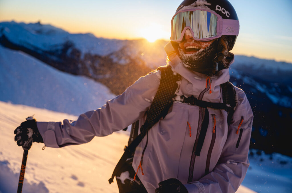 A skier smiles as they enjoy the slopes of Whistler Blackcomb as the sun dips behind the Coast Mountains.