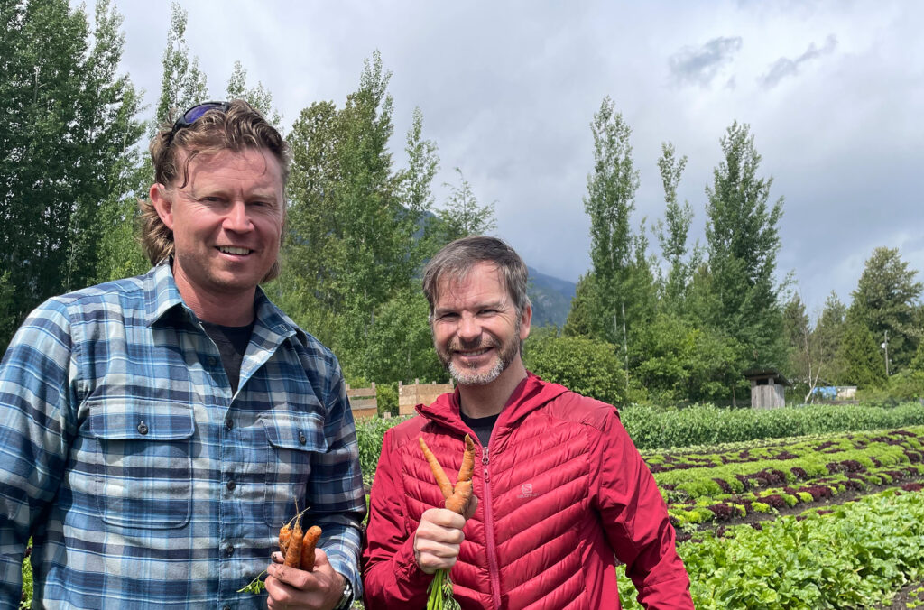 Eric Griffith from Alta Bistro and Mike Douglas stand in the lush fields of Root Down Farm in Pemberton.